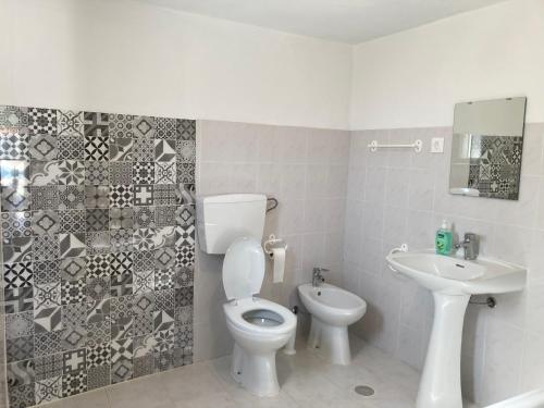a bathroom with a toilet and a sink at Monte das Cerejas in Montes da Senhora