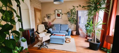 sala de estar con sofá azul y silla en Superbe logement dans une maison de caractère en Toul
