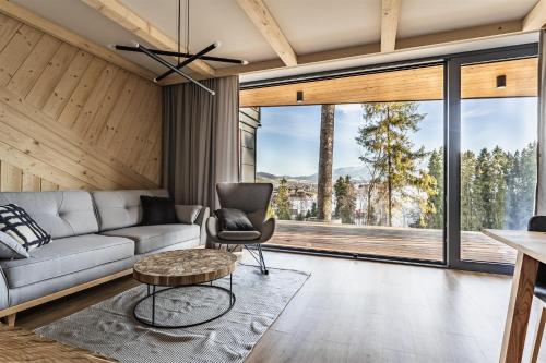 a living room with a couch and a table at Rezydencja Boutique SKI - 200m do Term Bania, Odkryj-Bialke in Białka Tatrzańska