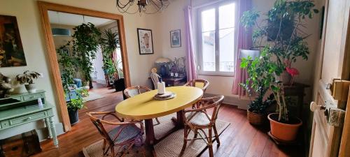 una mesa y sillas en una habitación con plantas en Superbe logement dans une maison de caractère en Toul