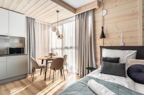 1 dormitorio con 1 cama y 1 mesa con sillas en Rezydencja Boutique SKI - 200m do Term Bania en Białka Tatrzanska