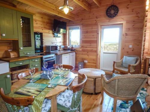 een keuken met een tafel en stoelen in een huisje bij Aurora Skies in Cresswell