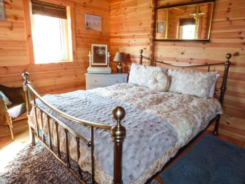 een slaapkamer met een bed in een blokhut bij Aurora Skies in Cresswell