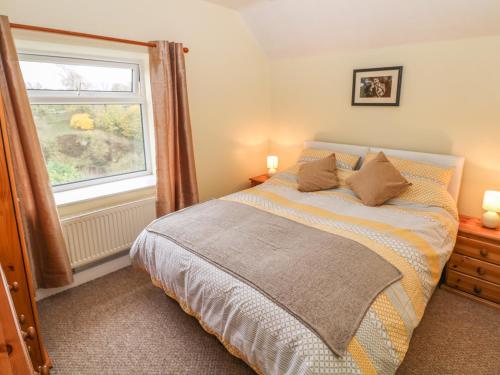 a bedroom with a bed and a window at Pine Cottage in Bakewell