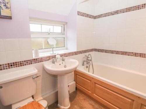 a bathroom with a sink and a toilet and a tub at Pine Cottage in Bakewell