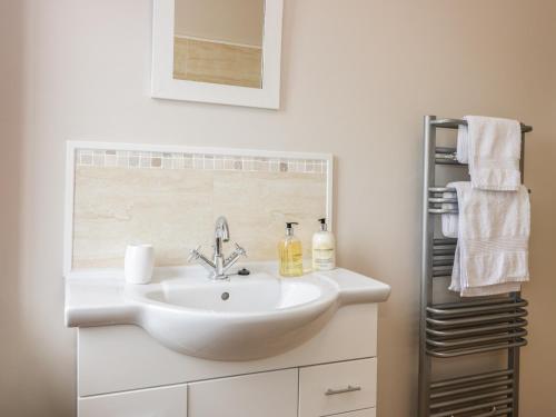 a bathroom with a white sink and a towel rack at Sea Lily in Cheswick