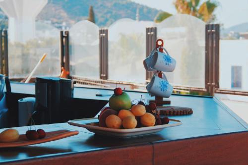 une table avec une assiette de fruits sur une table dans l'établissement La Luna Hostel, à Bodrum City
