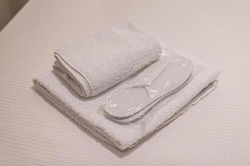 una pila de toallas blancas sentadas en una mesa en Dema's Luxury Suites en Athens