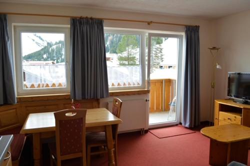 a dining room with a table and two windows at Landhaus Cornelia in Berwang