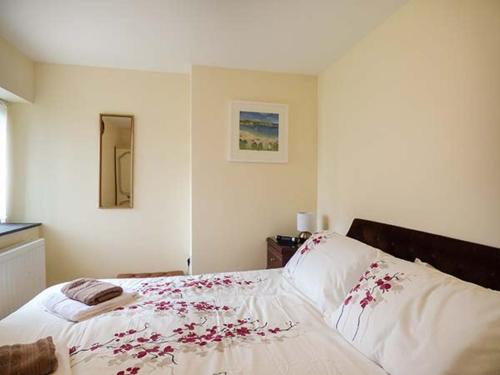 um quarto com uma cama com flores vermelhas em Shepherds Rest em Warbstow