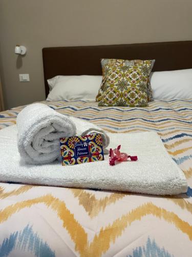 a bed with a pile of towels and a blanket at SicilyHouse Palermo in Palermo