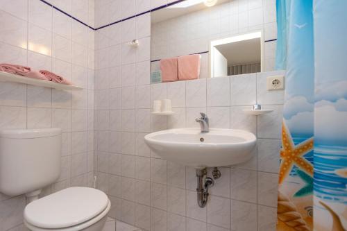 a white bathroom with a toilet and a sink at Pension Zum Lindeneck in Lübz