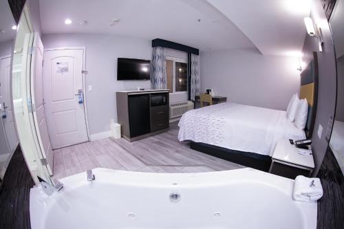 a bathroom with a bed and a tub in a room at Travelodge Inn & Suites by Wyndham West Covina in West Covina
