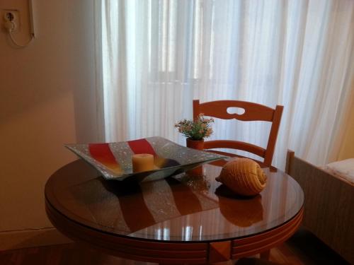 una mesa con un tazón de queso y una silla en Apartments Previšić, en Cavtat