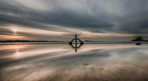 a reflection of a light pole on a beach at Hôtel Bristol Union Intra Muros in Saint Malo