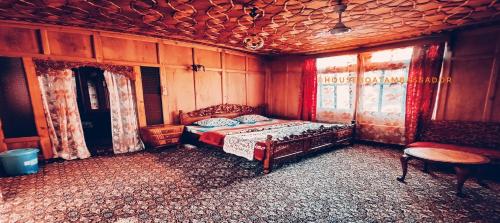 a bedroom with a bed and a table at Houseboat Ambassador in Srinagar