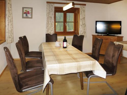 uma sala de jantar com uma mesa e cadeiras e uma televisão em Apartment Luftbichl - SLB130 by Interhome em Viehhofen