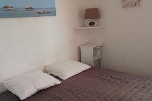 a bedroom with a bed with two pillows on it at T2 1ère ligne loggia vue mer 180 ° parking in Arcachon