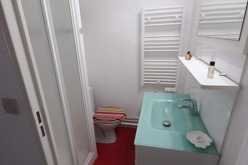 a bathroom with a green sink and a toilet at T2 1ère ligne loggia vue mer 180 ° parking in Arcachon