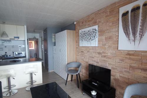 un salon avec un mur de briques dans l'établissement T2 1ère ligne loggia vue mer 180 ° parking, à Arcachon