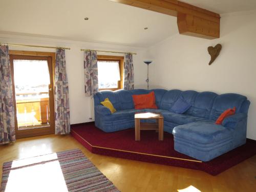 sala de estar con sofá azul y mesa en Apartment Liftblick - NKI190 by Interhome, en Neukirchen am Großvenediger