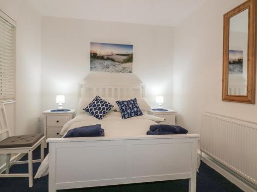 a bedroom with a white bed with blue pillows at Sea Breezes in Newquay