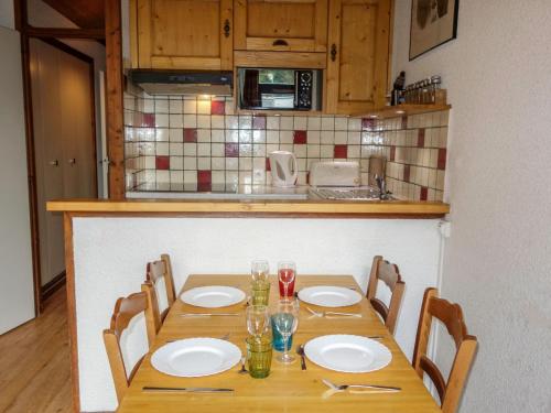 einen Holztisch mit Stühlen und Tellern darauf in der Küche in der Unterkunft Apartment Le Brûlaz by Interhome in Les Contamines-Montjoie