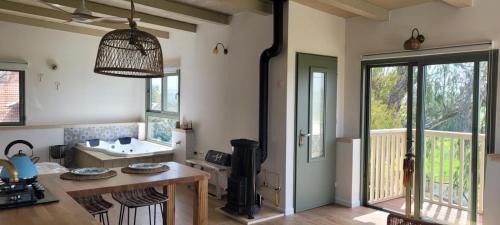 a room with a kitchen with a sink and a table at צימר חלון לרקפות zimer Window for primroses עם ג'קוזי לנוף in Tal Shaẖar