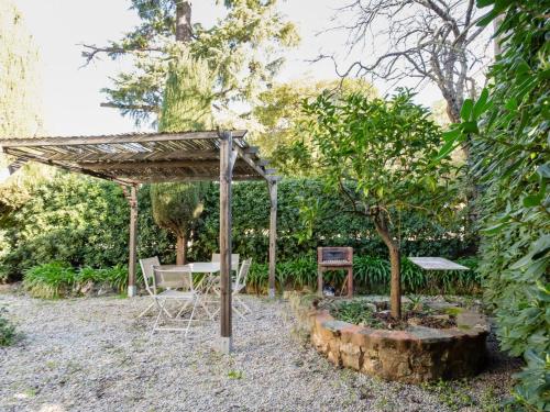 un jardin avec une table et des chaises sous une pergola dans l'établissement Apartment Lou Mi-Re by Interhome, à Cannes