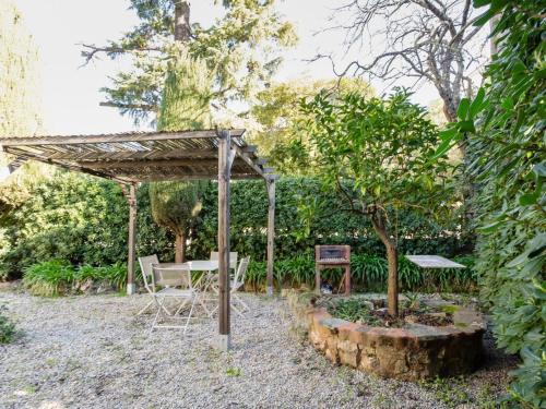 a garden with a table and chairs under a pergola at Apartment Lou Mi-Re by Interhome in Cannes