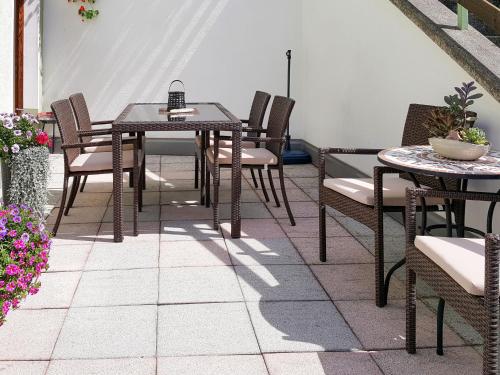 eine Terrasse mit Tischen, Stühlen und Blumen in der Unterkunft Apartment Walch - PTZ410 by Interhome in Fendels