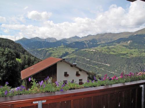 a house with flowers on a fence with a mountain at Apartment Alpenherz - PTZ431 by Interhome in Fendels