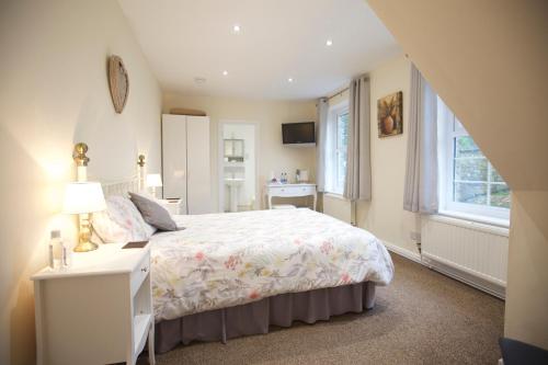 1 dormitorio con cama, escritorio y ventana en Trelaske Manor B&B, en Launceston