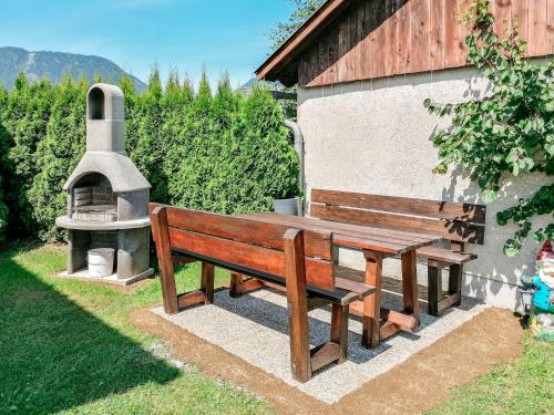 a wooden bench next to a building with a pizza oven at Holiday Home Katharina - GBM220 by Interhome in Gröbming