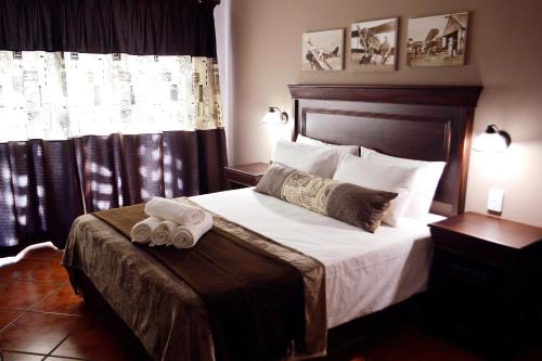 a bedroom with a bed with two towels on it at Barnstormers Rest in Malelane