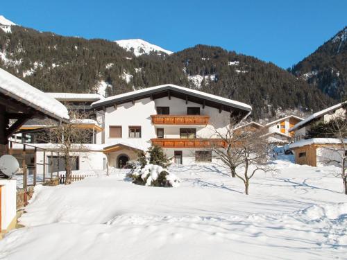 a building in the snow with mountains in the background at Apartment Mangard - GOP211 by Interhome in Sankt Gallenkirch