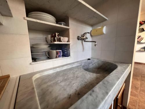 un grande lavandino in cemento in una cucina con piatti di Mansarda Sul Porticciolo 1b/1b 50mq with seaview a Genova