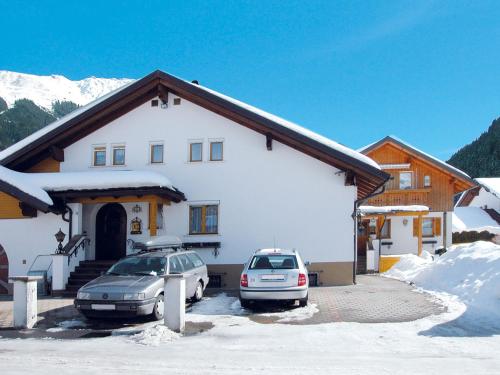 a house with two cars parked in front of it at Apartment Hödl - TCH180 by Interhome in Schruns