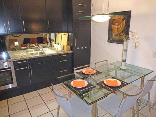 a kitchen with a glass table and some chairs at Apartment Collina Verde B by Interhome in Ascona