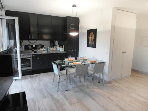 eine Küche mit einem Esstisch und Stühlen in der Unterkunft Apartment Collina Verde B by Interhome in Ascona