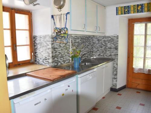 eine Küche mit weißen Schränken und einem Waschbecken in der Unterkunft Holiday Home Villa Roduit by Interhome in Le Châble