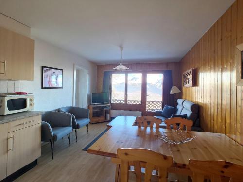 eine Küche und ein Wohnzimmer mit einem Tisch und Stühlen in der Unterkunft Apartment Bellevue L by Interhome in Veysonnaz