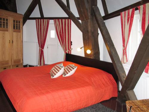 a bedroom with a red bed with two pillows at Holiday Home Sielmühle by Interhome in Middelsbur