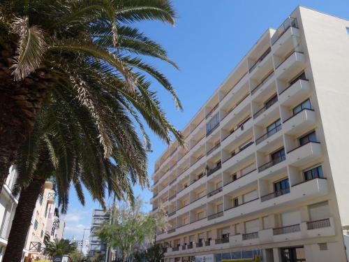 a building with a palm tree in front of it at Apartment Alphonse XIII by Interhome in Biarritz