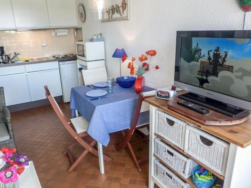- une cuisine avec une table, une télévision, une table et des chaises dans l'établissement Apartment Du Soleil-2 by Interhome, à La Grande Motte
