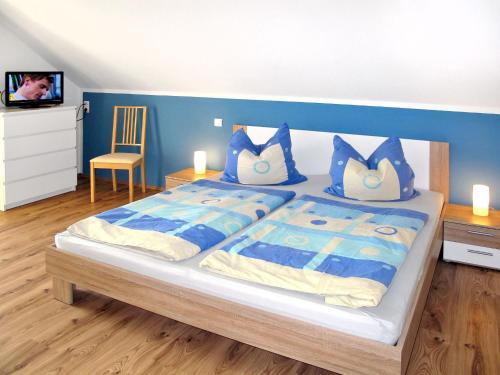 a bedroom with a large bed with blue walls at Holiday Home Johannika by Interhome in Godern