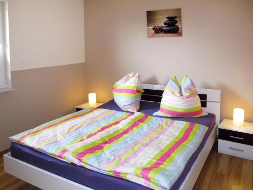 a bedroom with a bed with colorful sheets and pillows at Holiday Home Johannika by Interhome in Godern