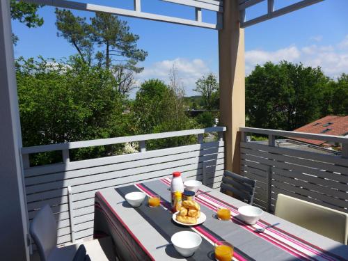 une table avec une assiette de nourriture sur un balcon dans l'établissement Apartment Les Demeures de Brindos by Interhome, à Anglet