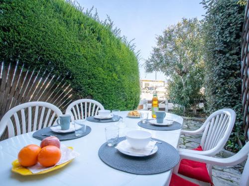 une table blanche avec des assiettes de fruits sur elle dans l'établissement Holiday Home Port Nautile-1 by Interhome, au Grau-du-Roi