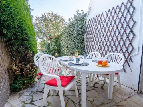 - une table et des chaises blanches sur la terrasse dans l'établissement Holiday Home Port Nautile-1 by Interhome, au Grau-du-Roi